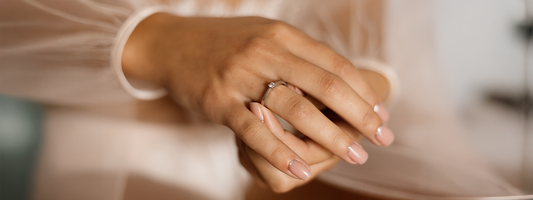 engagement ring on an elegant hand with natural colored manicure